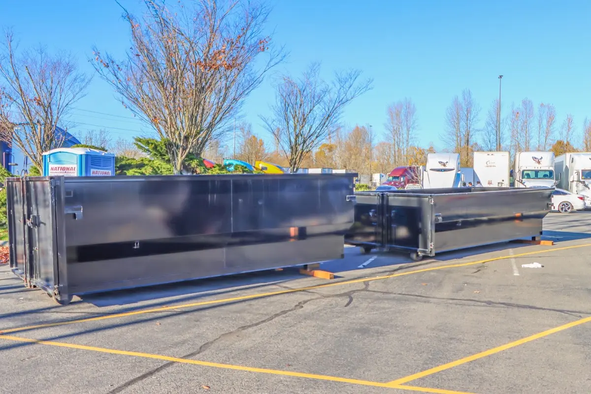 Professional dumpster rental service with roll-off container on residential driveway in Home Gardens